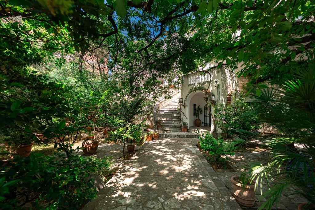 Garden courtyard and stone path leading to Hotel Dubrava